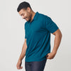Man wearing Teal Short Sleeve Polo with dark jeans.