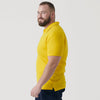 Man wearing Yellow Classic Polo with dark pants, slight smile.