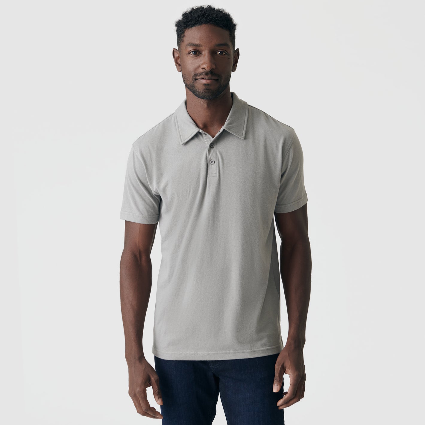 Man wearing Iron Gray Short Sleeve Polo with dark trousers.