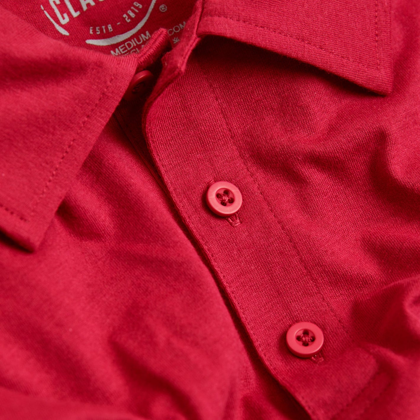Raspberry Classic Polo collar and buttons close-up.