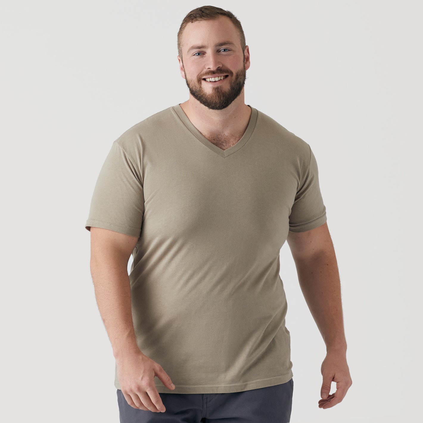 Man wearing Military Beige Classic V-Neck T-shirt, smiling, light background.