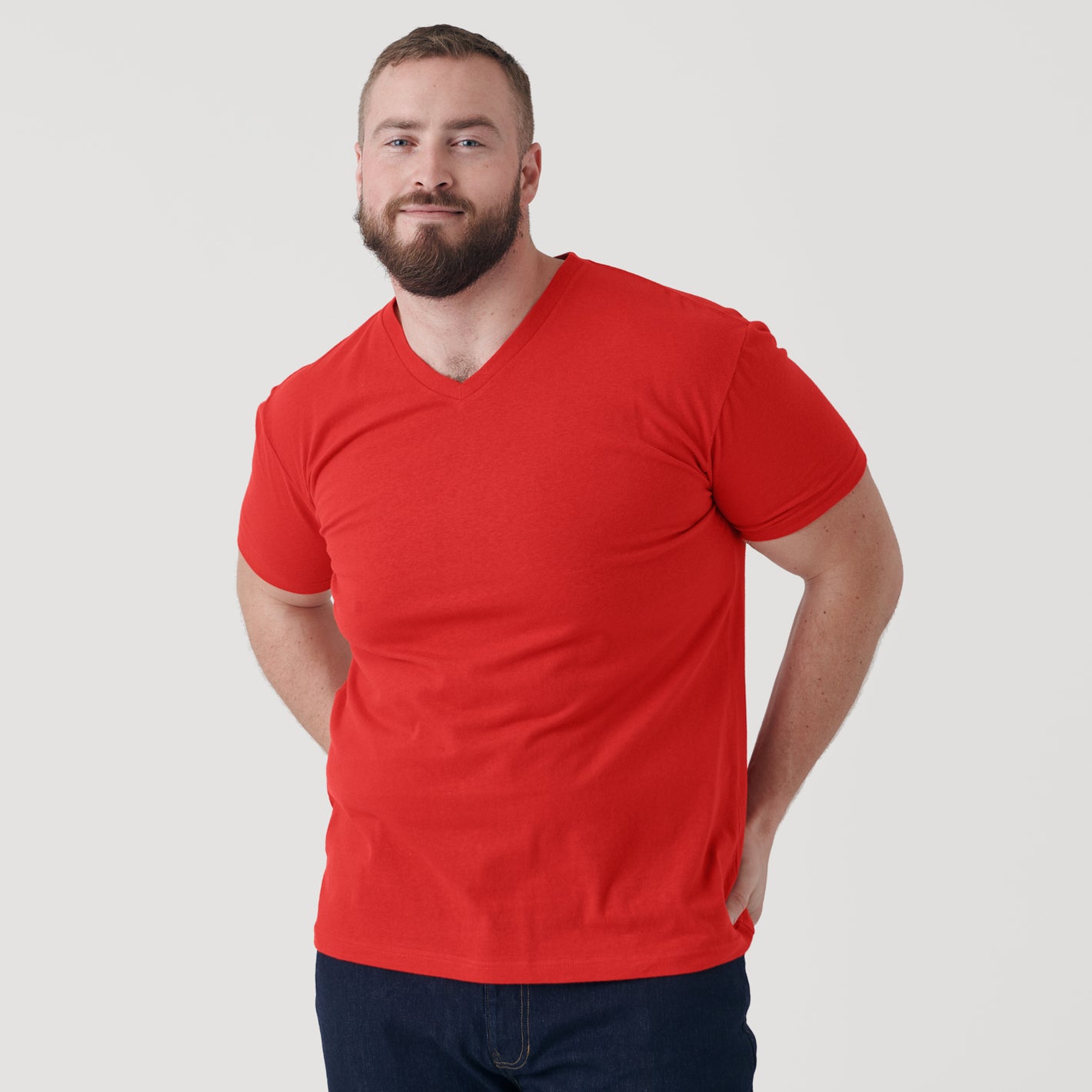 Man modeling True Red V-Neck Tee with slight smile.