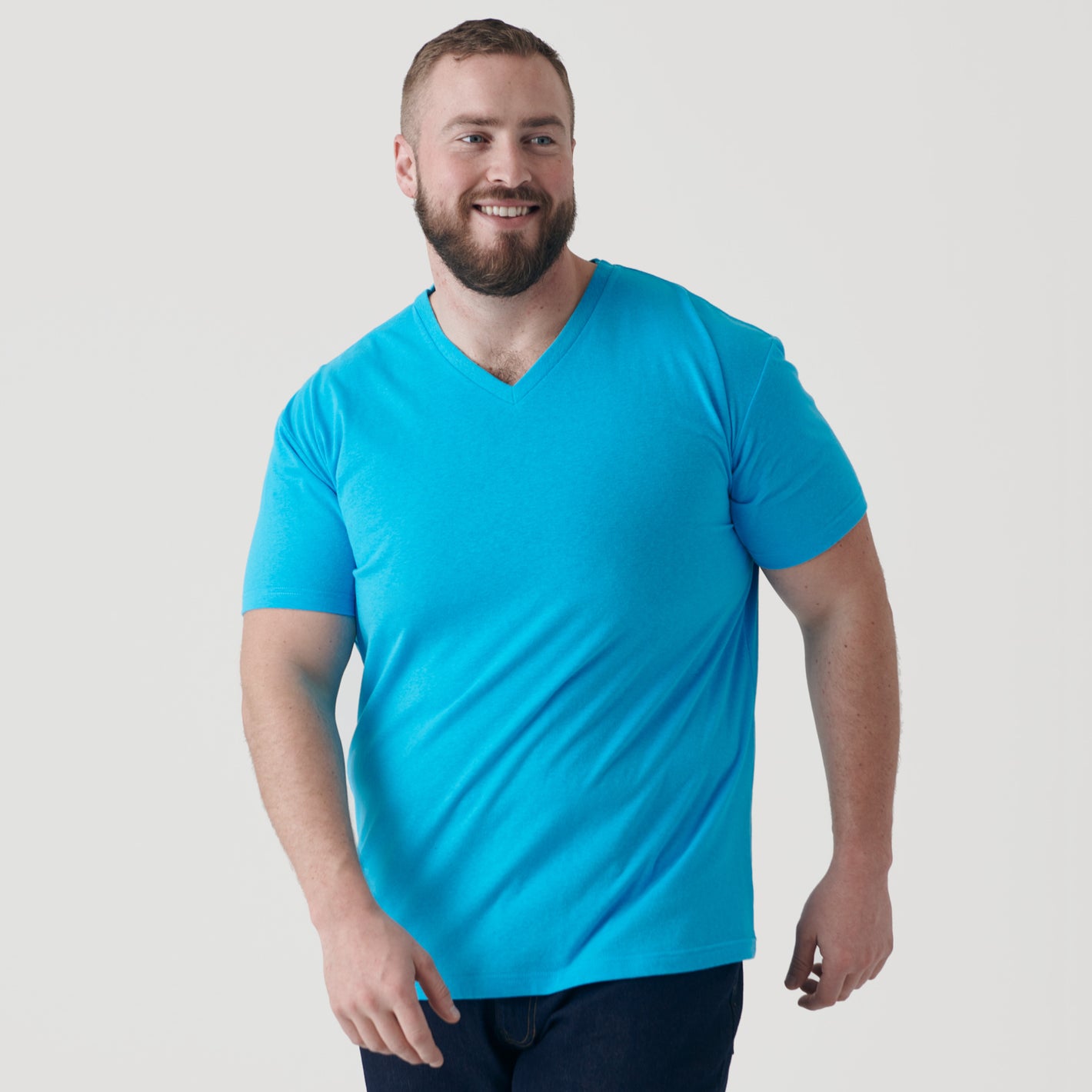 Man in Turquoise V-Neck Tee smiling.