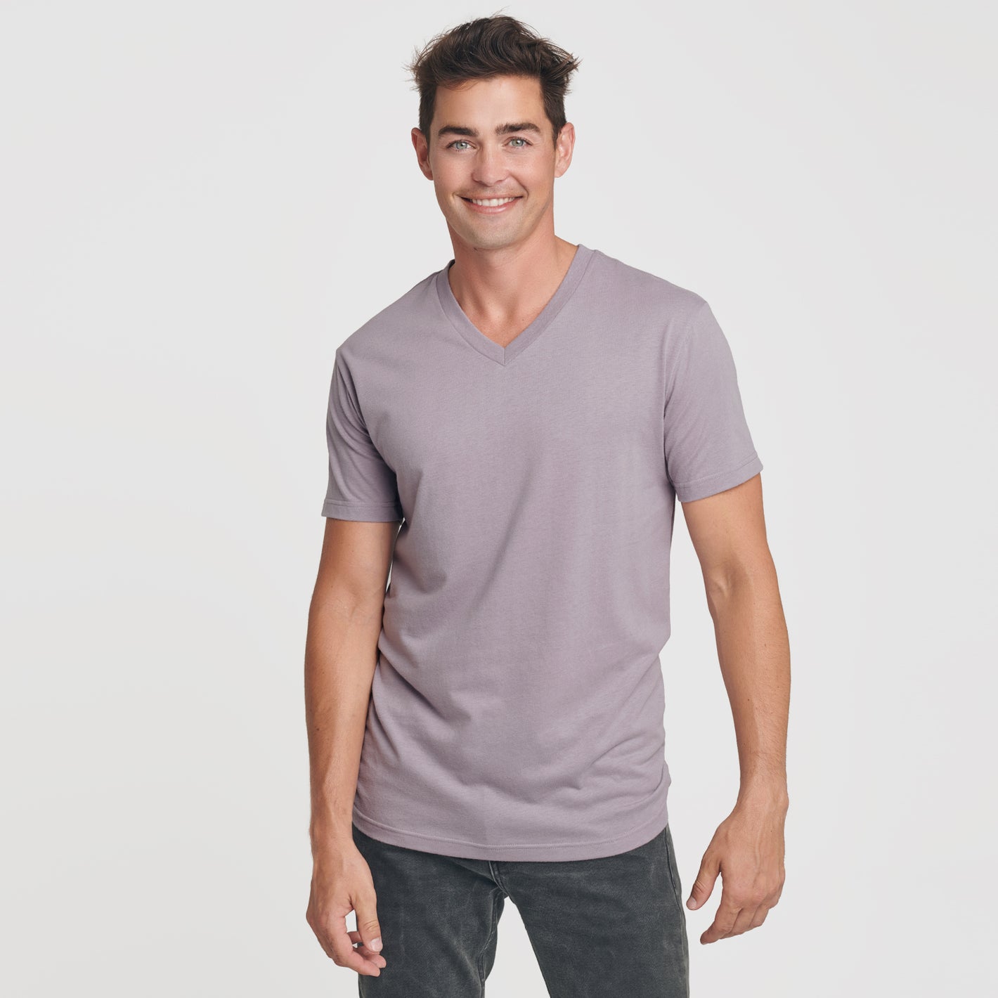 Man wearing Flint V-Neck Tee with dark jeans, smiling.