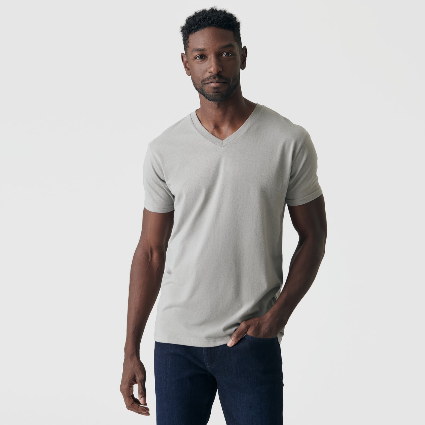 Man wearing Iron Gray Classic V-Neck and jeans, neutral expression.
