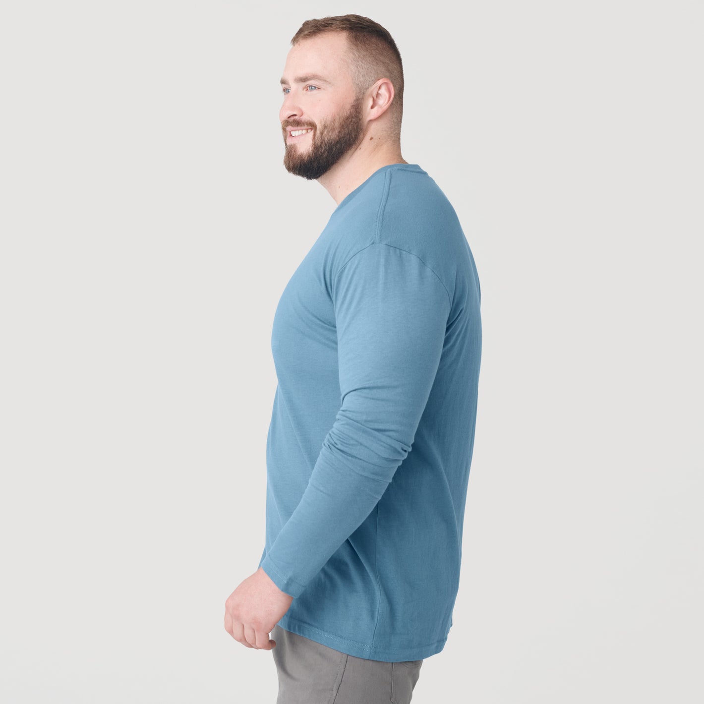Man wearing Bluestone Long Sleeve Crew Neck Tee and gray pants.