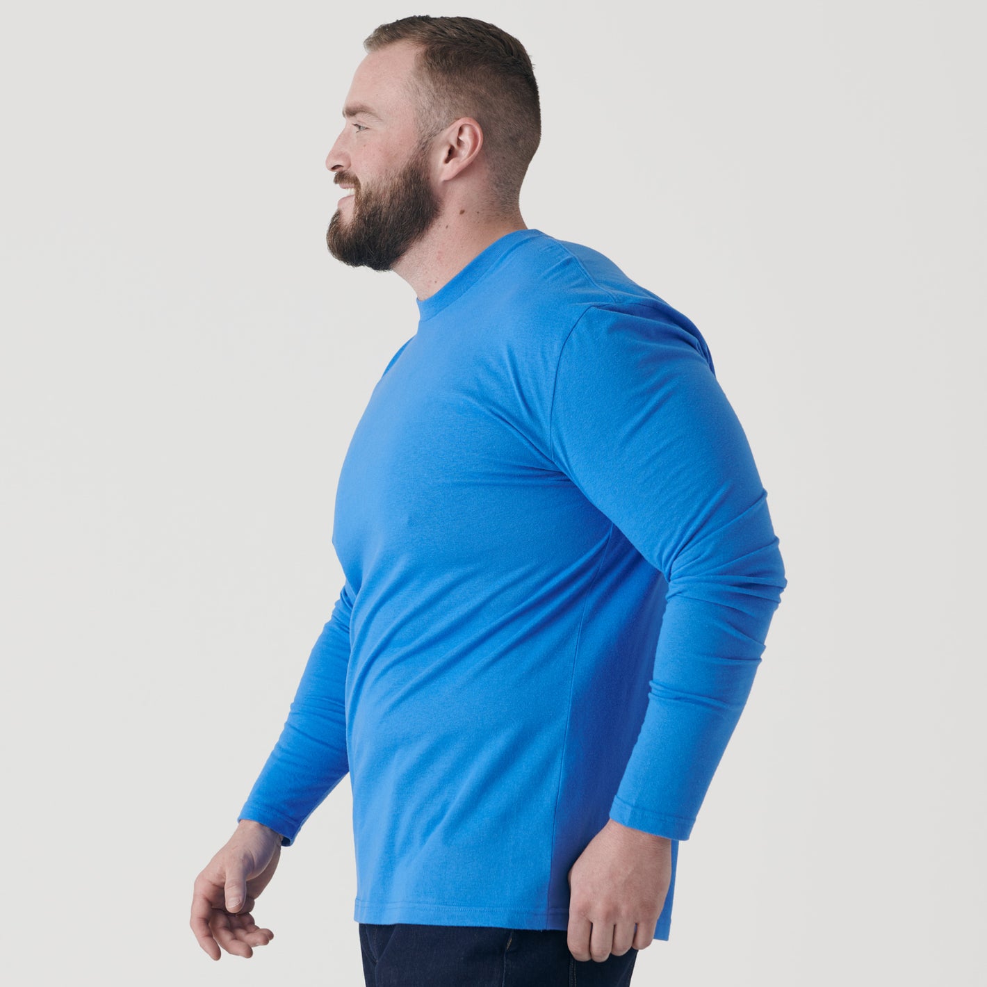 Man in profile wearing Periwinkle Blue Long Sleeve Crew Neck Tee.