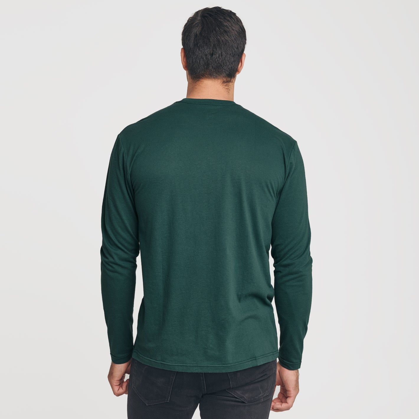 Man in Forest Green Long Sleeve Crew Neck Tee, rear view.