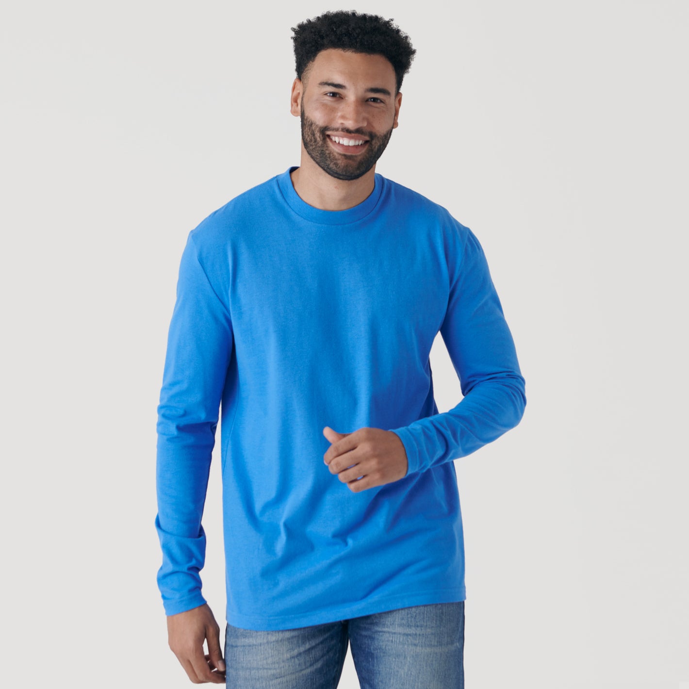 Man in Periwinkle Blue Long Sleeve Crew Neck Tee, smiling.