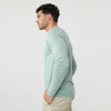 Man in Sage Long Sleeve Crew Neck Tee, hands in pockets, side view.