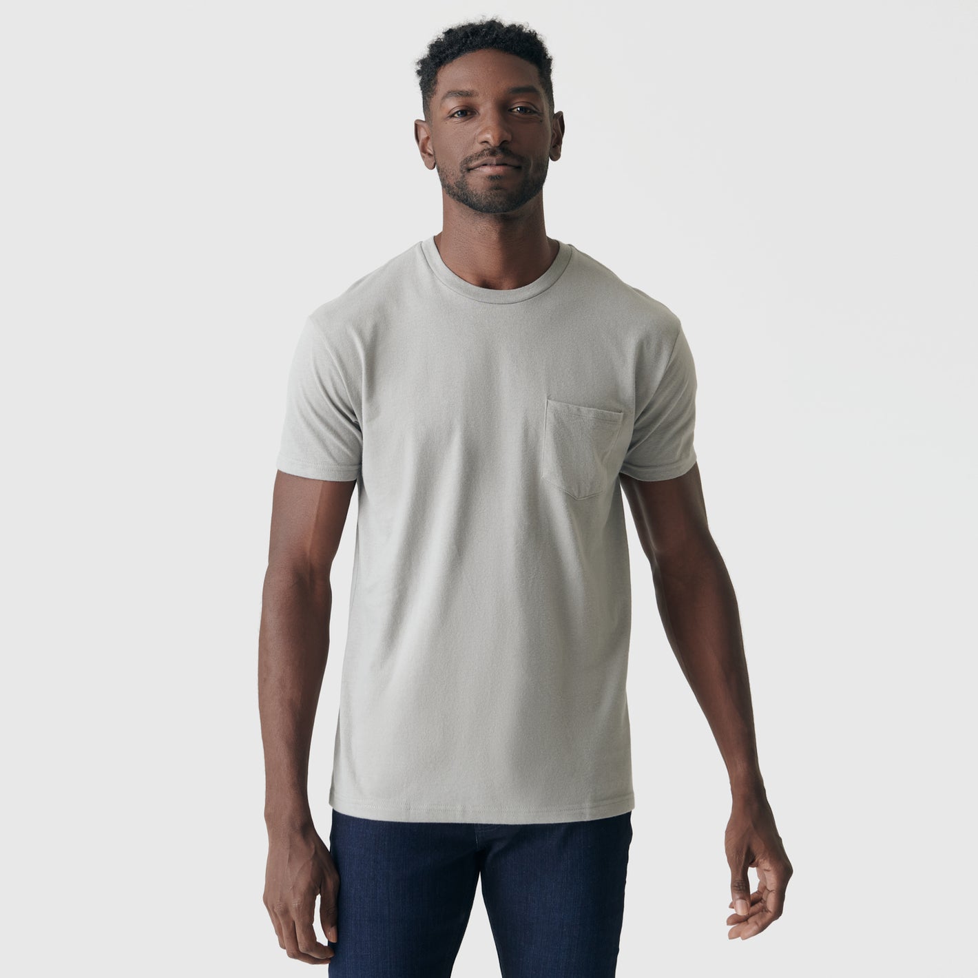 Man wearing Iron Gray Pocket Crew Tee with dark trousers.