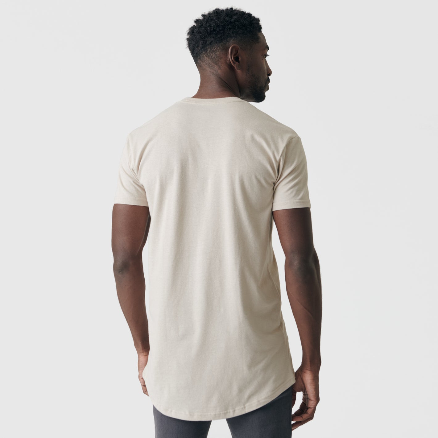 Man wearing Sandstone Tall Round Hem Crew Neck T-Shirt, side view.