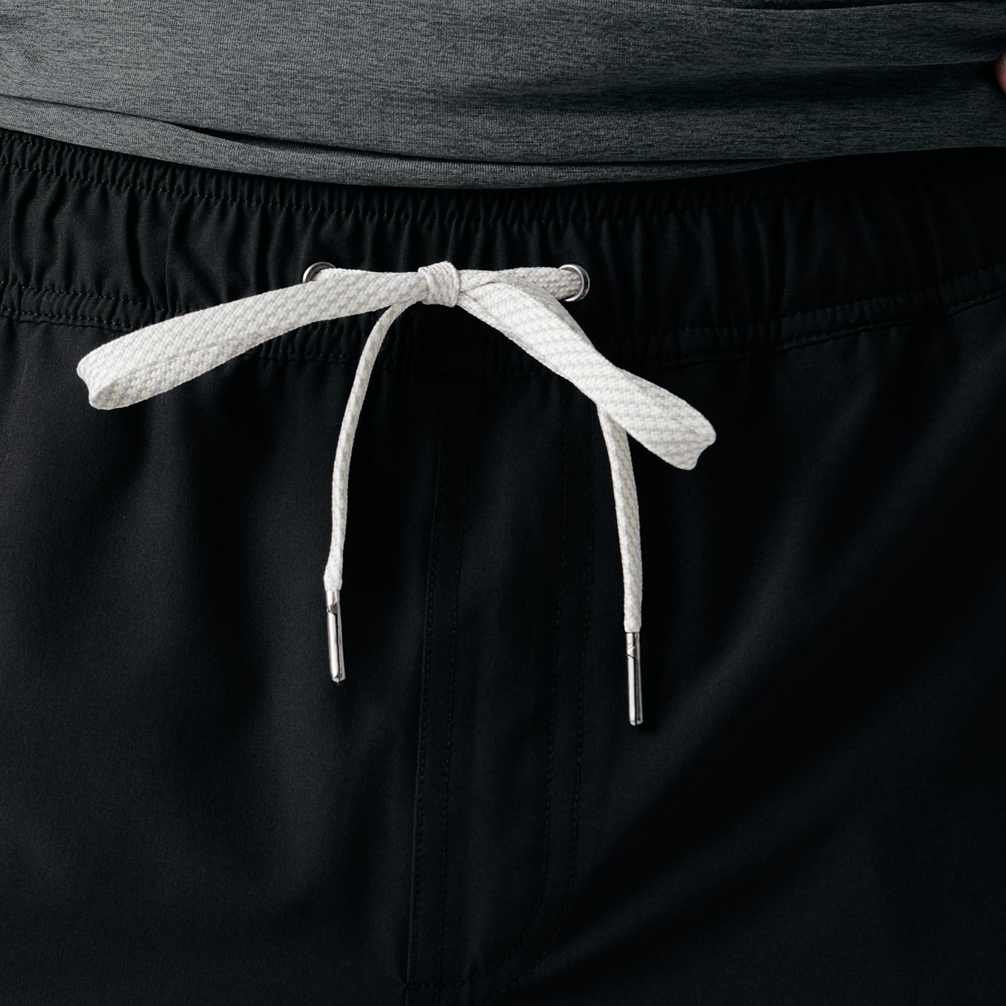 Black elastic waistband with white drawcord of 7 All Black Active Quick Dry Shorts.