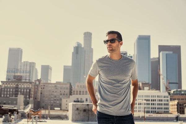 Man wearing True Classic Heather Gray Crew Neck T-Shirt on rooftop looking over a city skyline