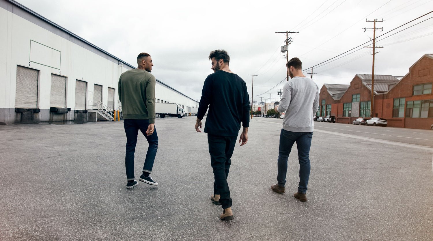 Three guys walking away wearing jeans