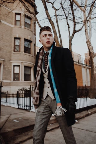 Model wearing Valentine's Day outfit featuring an overcoat, vest, and scarf.
