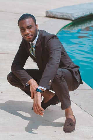 Model wearing a fitted suit with loafers without socks.