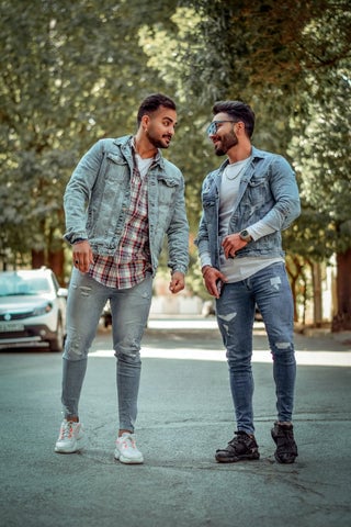 Two models wearing denim jackets with dress shirts underneath along with white-washed jeans.