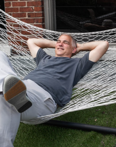 Middle aged man wearing True Classic Carbon Crew Neck Tee relaxing on a hammock. 