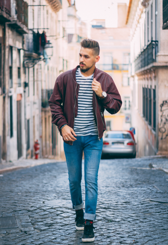 Man Wearing Street Clothes walking down a cobblestone road