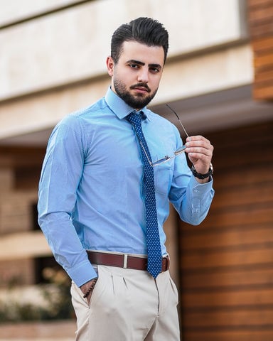 Man wearing khaki brown pant and light blue button down shirt
